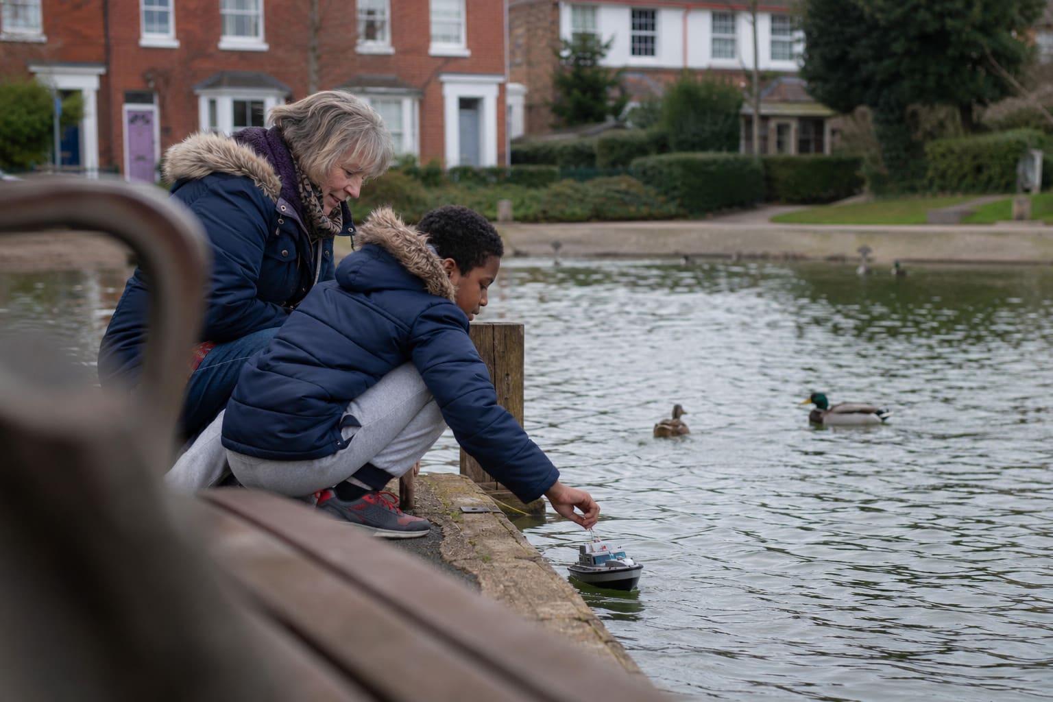 A foster carer and a child spending a weekend afternoon together outdoors.